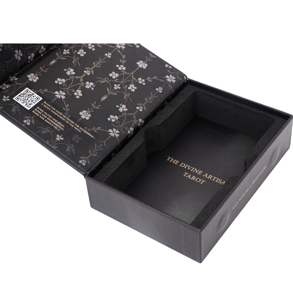 Close-up view of The Divine Artisan Tarot box and cards with elegant dark artwork